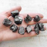 noble elite shungite stones on a hand