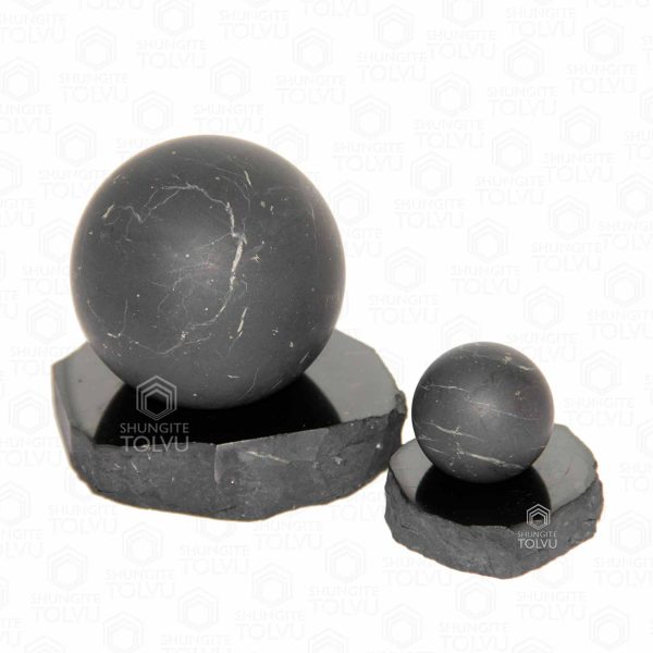 unpolished sphere on a black stone support